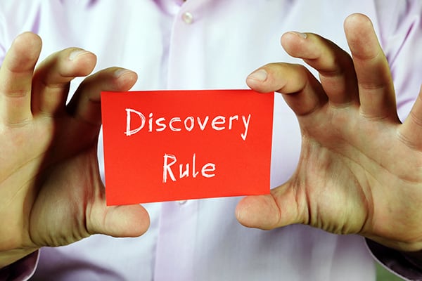 man holding discovery rule card