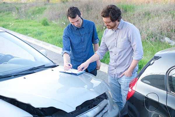 dos hombres en houston intercambian información sobre seguros después de un accidente