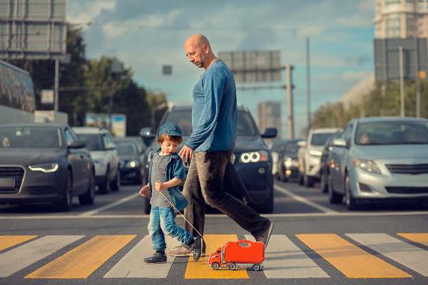 father and son use crosswalk to get to their destination in houston  