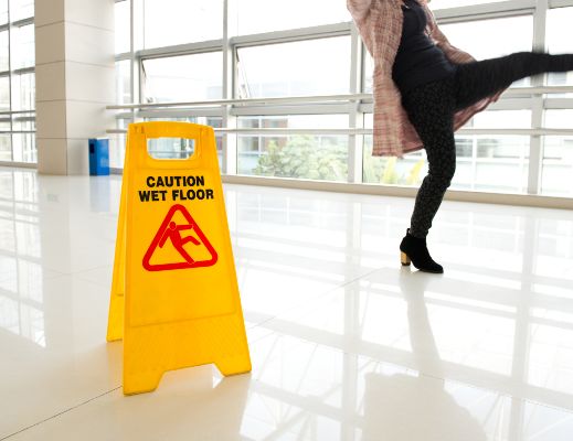 a woman slips on a recently mopped floor