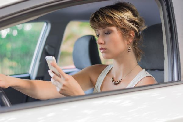 una niña envía mensajes de texto mientras conduce.